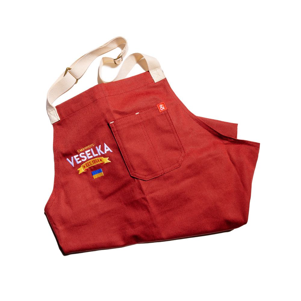 Red Veselka apron with Veselka logo embroidered on as well as a small embroidered Ukrainian flag