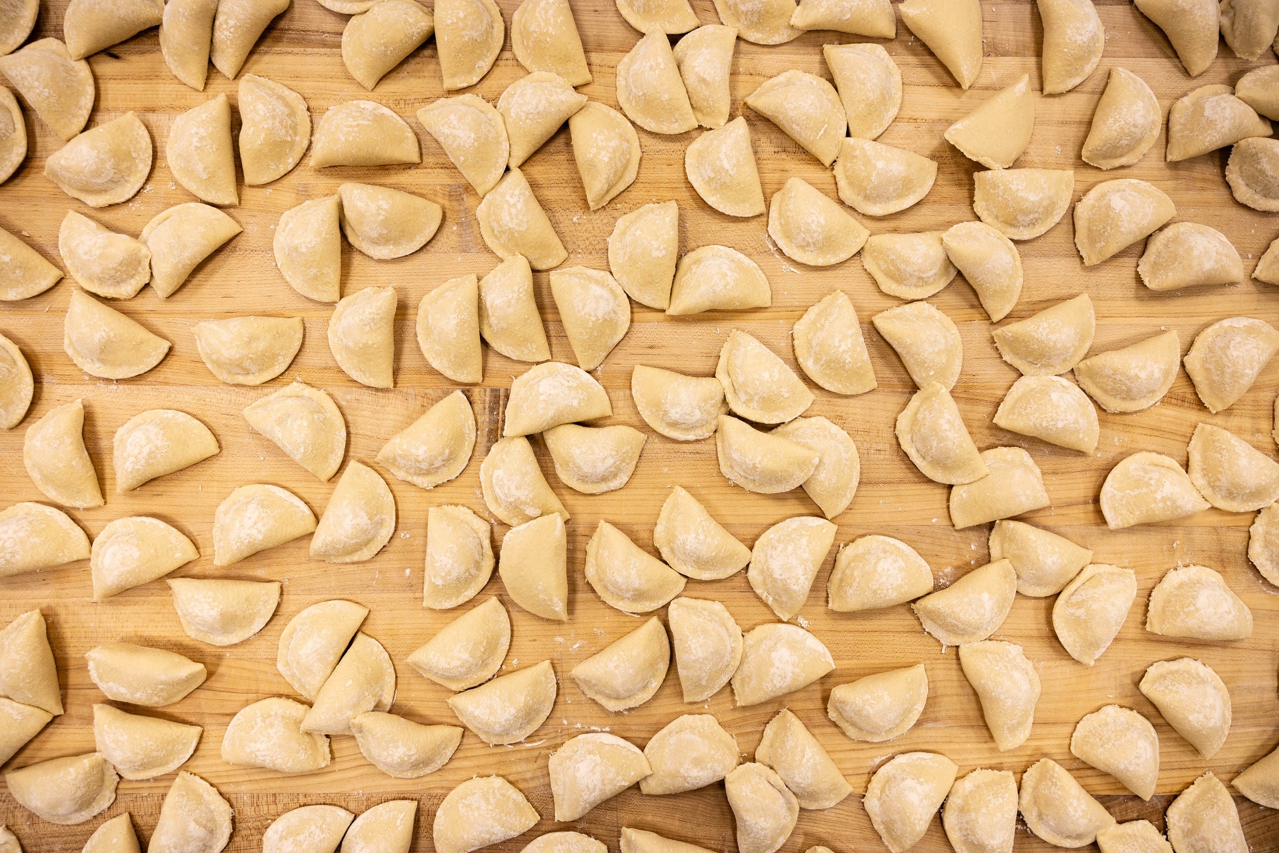 Uncooked ravioli on a wooden surface