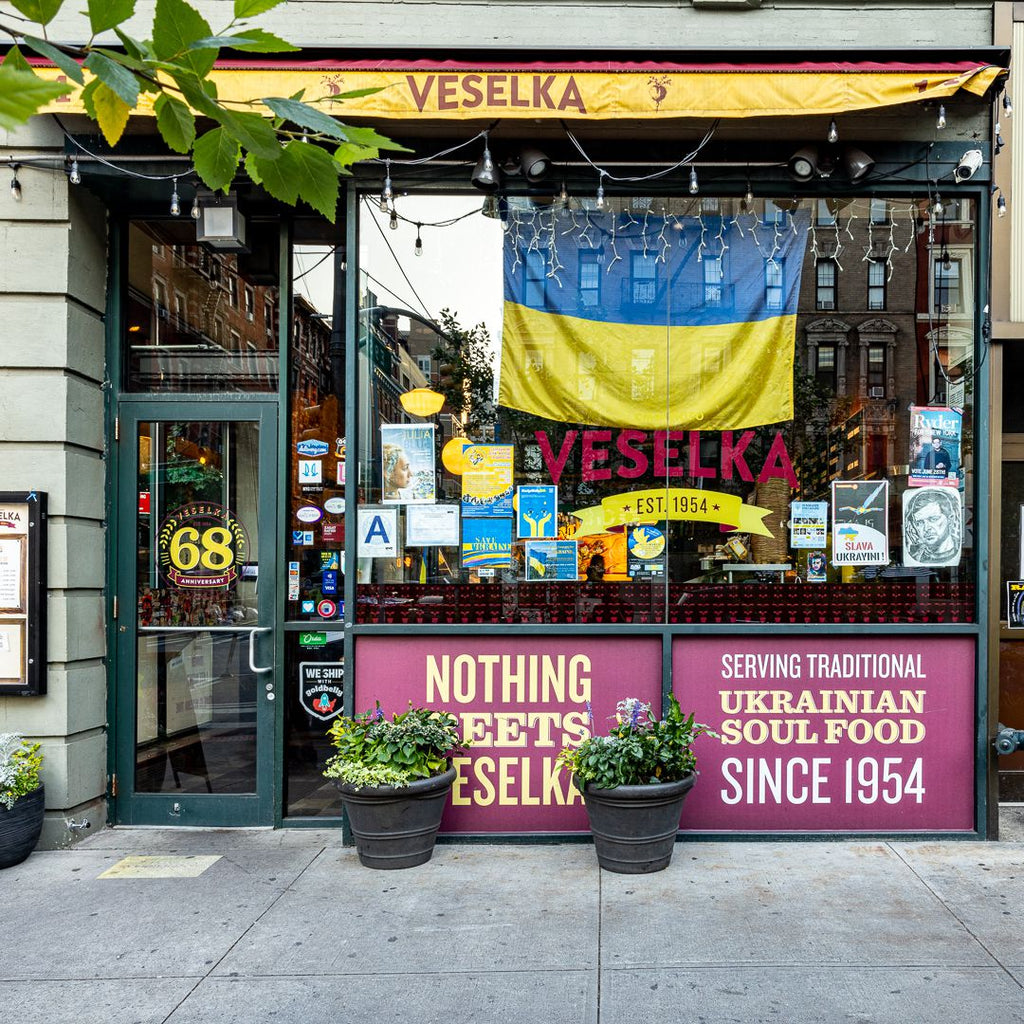 Veselka store front with Ukrainian flag in window, potted plants outside