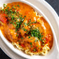 Chicken Paprikash with parsley sprinkled over the top, over egg noodles 