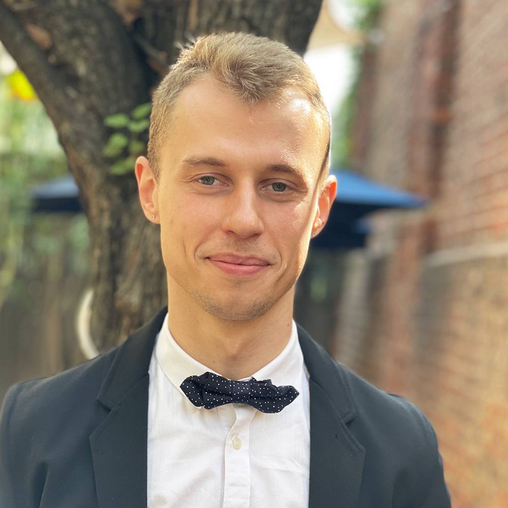 Vitalii, Ukrainian worker at Veselka in a suit and bow tie