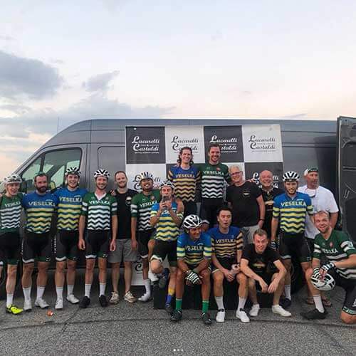 Veselka cycling team with Tom and Jason. All smiling in front of a van, mix of Ukraine jerseys and green and white jerseys 