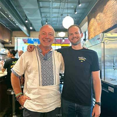 Justin and Jason in 2nd ave dining room smiling and hugging 