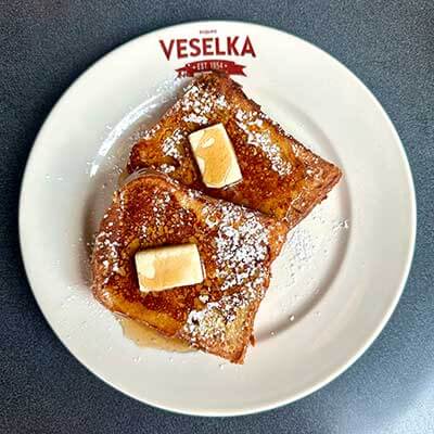 French toast on a plate with syrup and butter on top