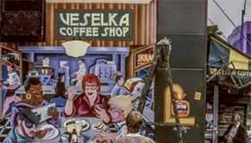 Veselka coffee shop mural being painted outside with Arnie the muralist pictured